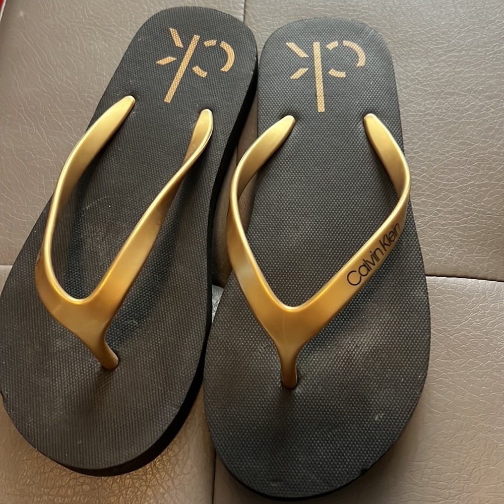 CK FLIP FLOPS in size 5M.  Black and metallic gold colors.